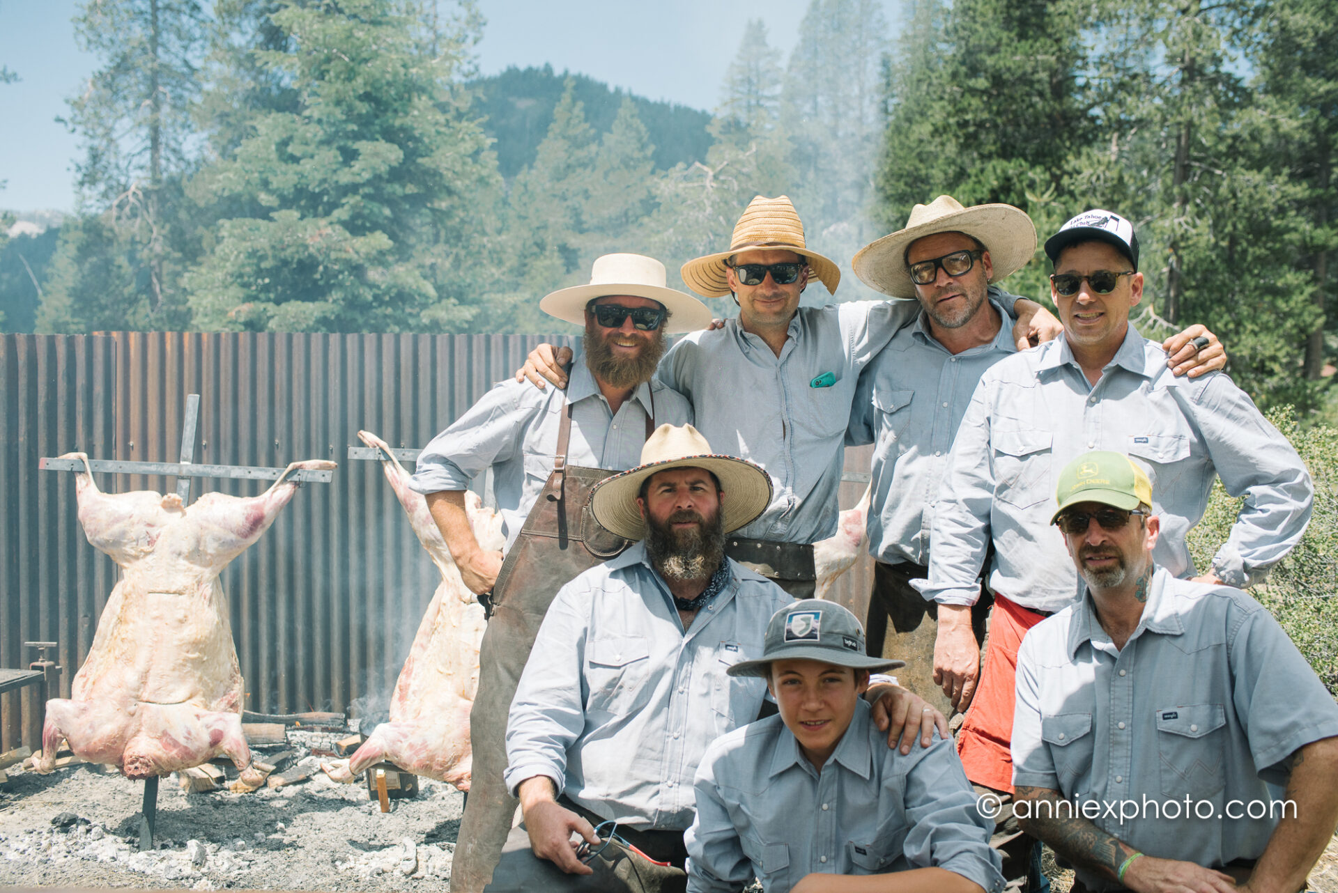 Group of men in front of a pig on a barbecue pit